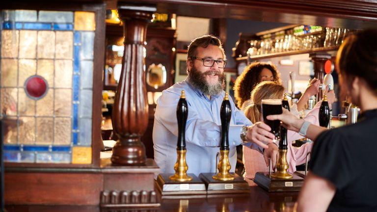 a barman serving a pint at the pub