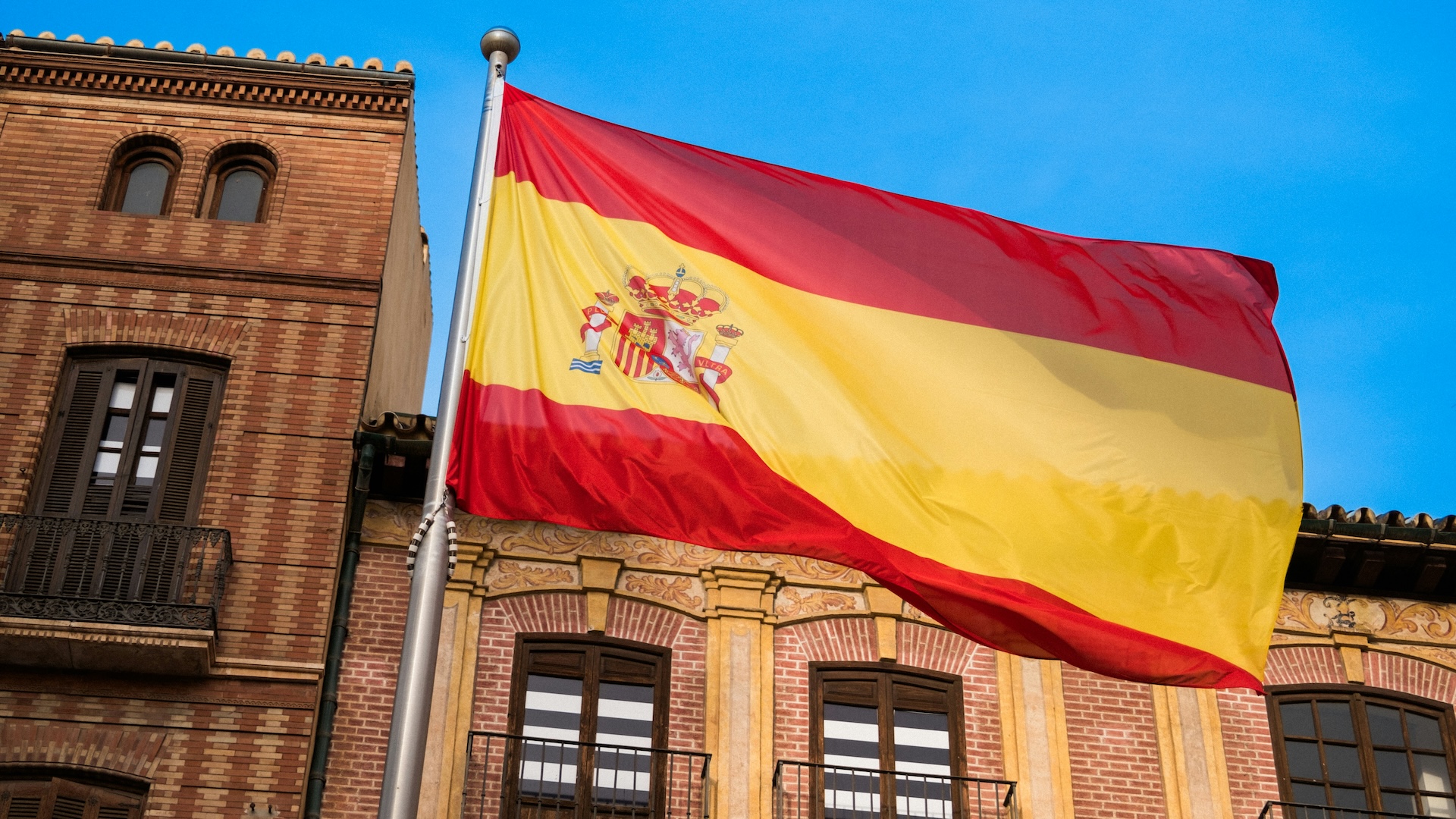 A Spanish flag flying in the street.