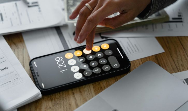 Stock image shows a person calculating their bills