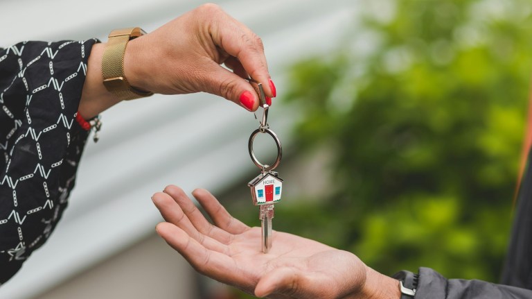 a hand putting a key into another hand