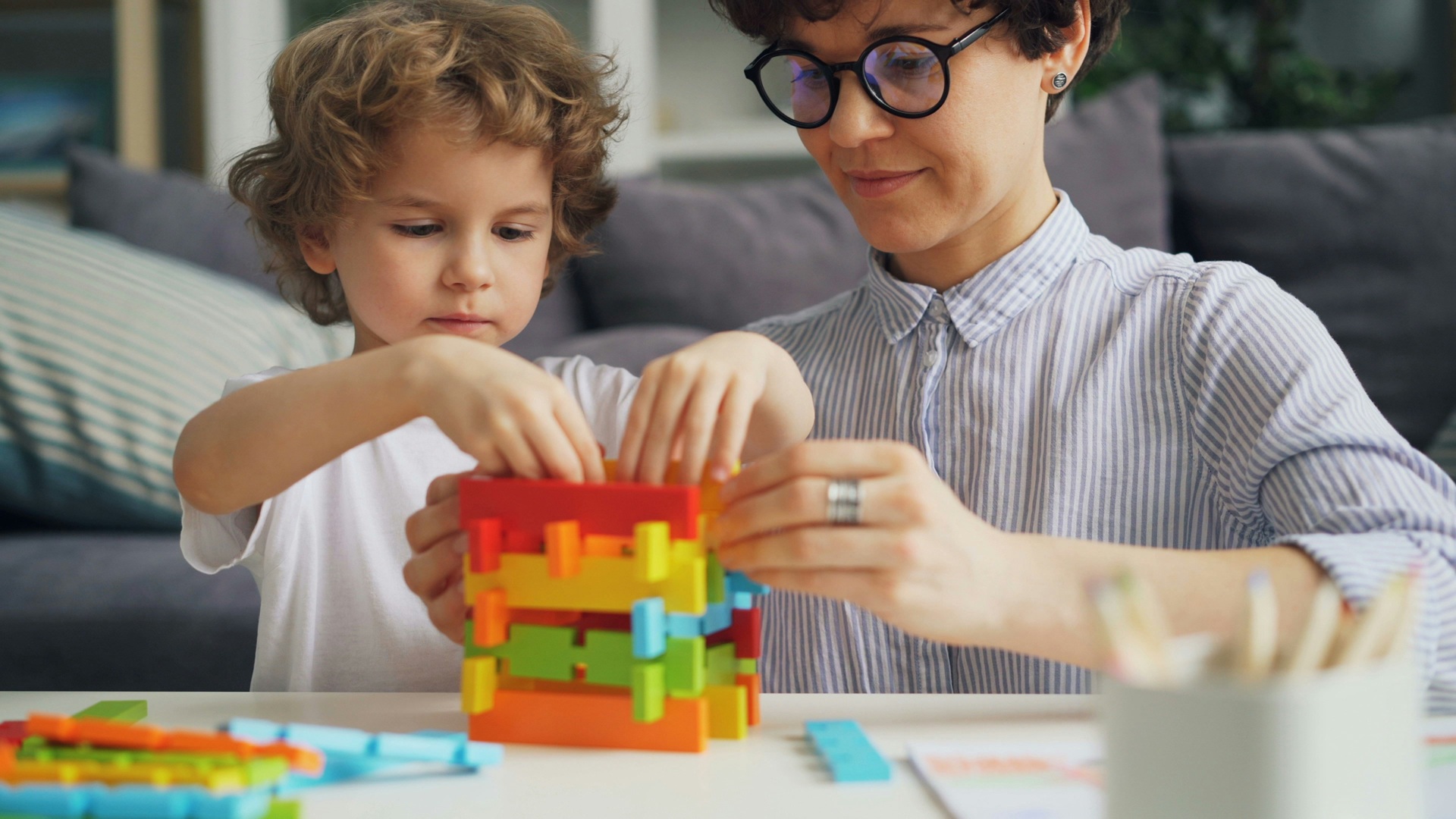 a child and a woman playing with building blocks