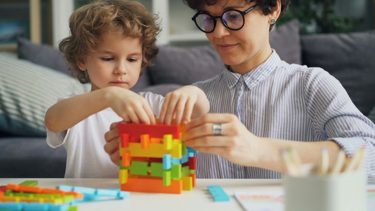 a child and a woman playing with building blocks