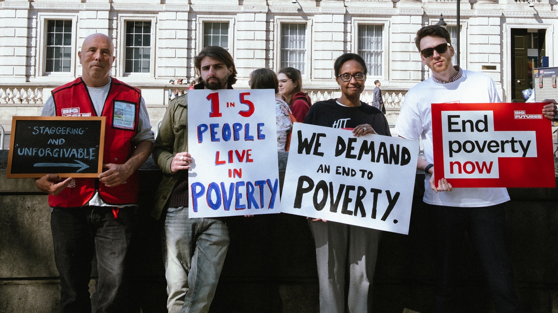 Big Issue vendors and staff with placards calling for action on poverty