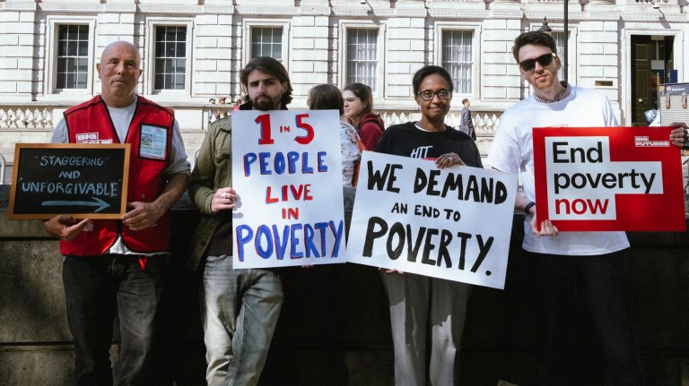 Big Issue vendors and staff with placards calling for action on poverty