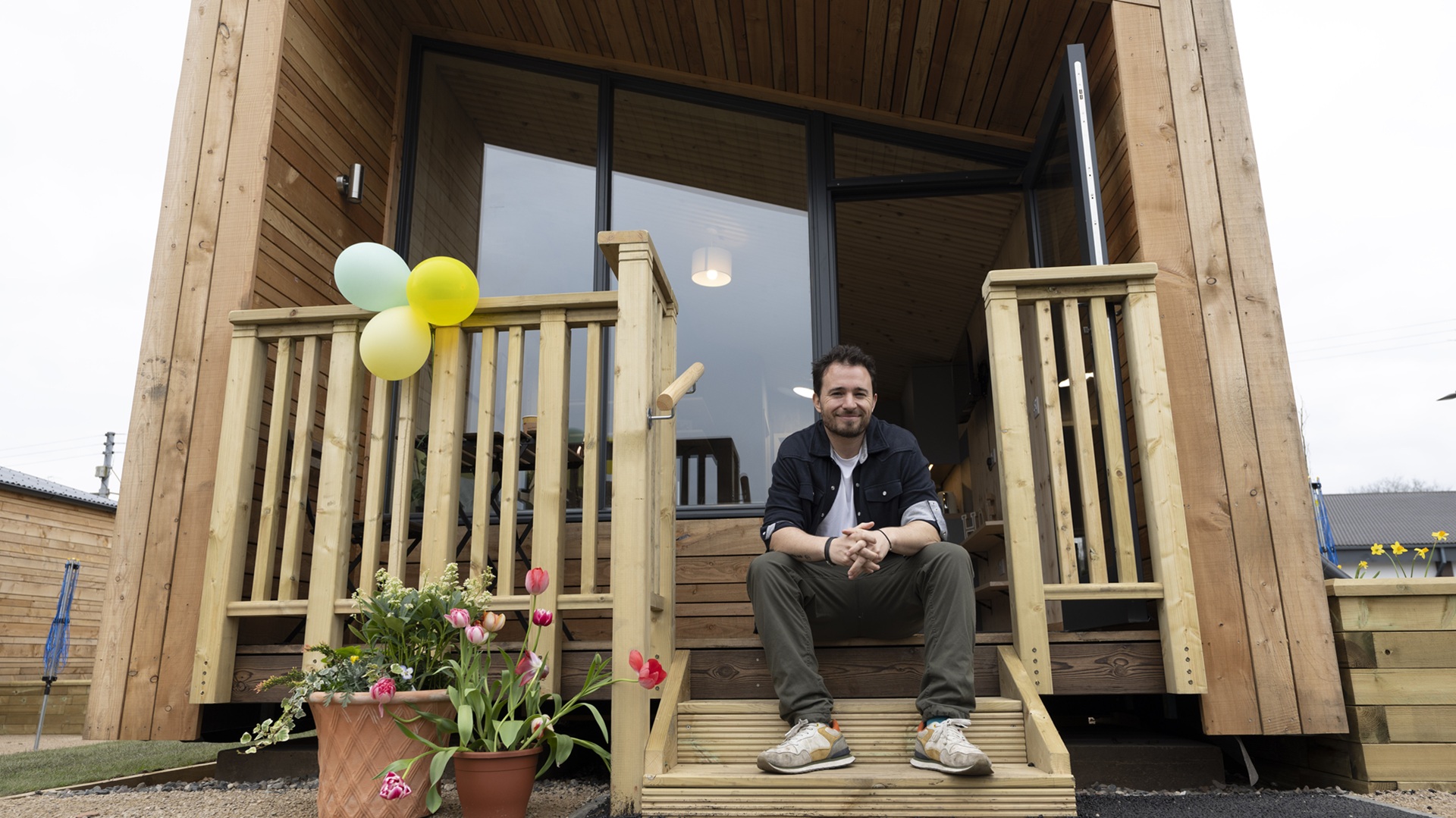 Social Bite co-founder Josh Littlejohn on the steps of one of the modular homes at the new Harriet Gardens village