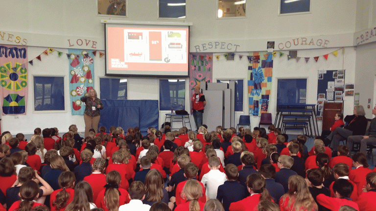 Big Issue Education programme shows a Big Issue vendor speaking to children in a school