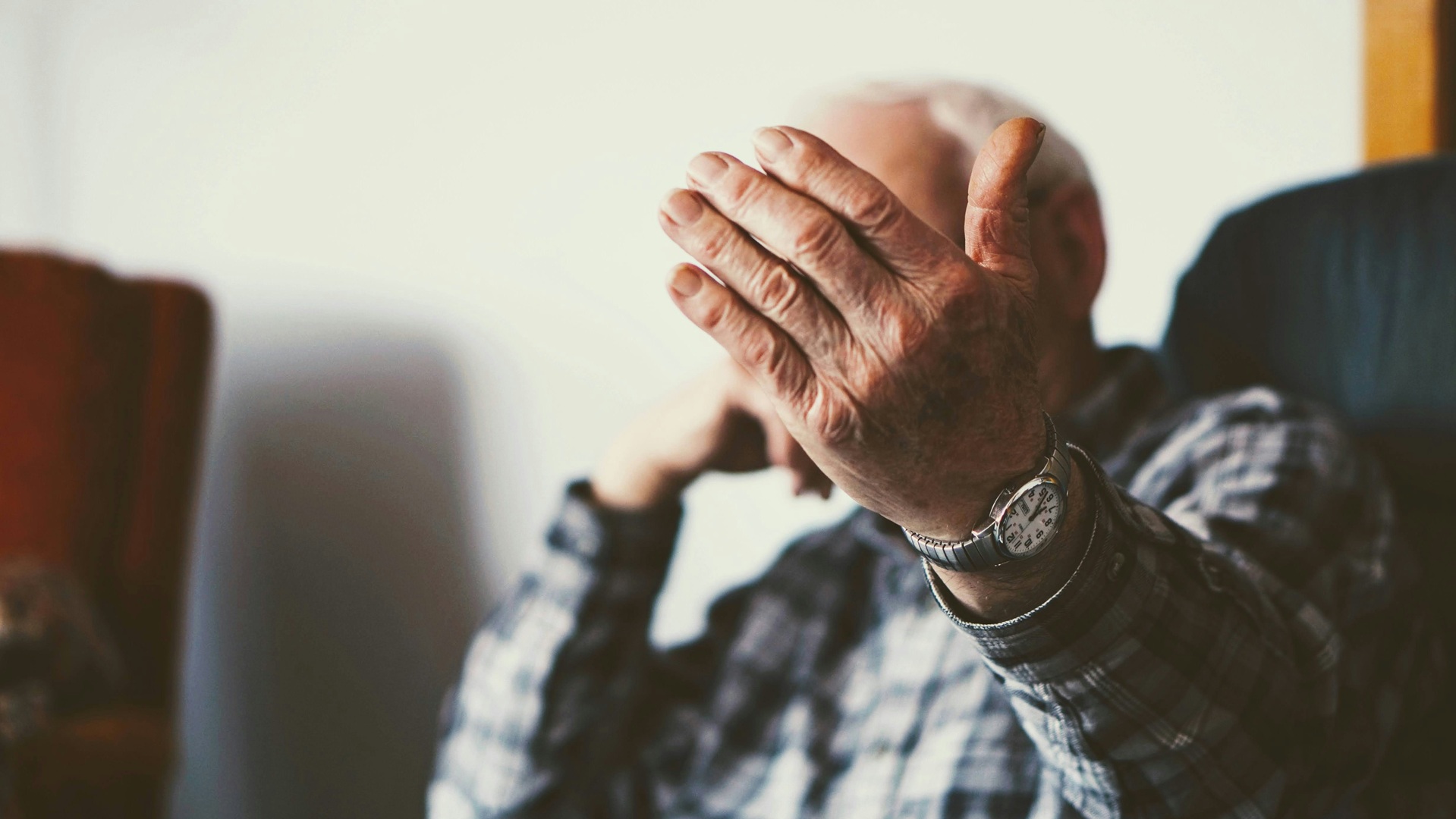 a stressed old man with his hand out in despair