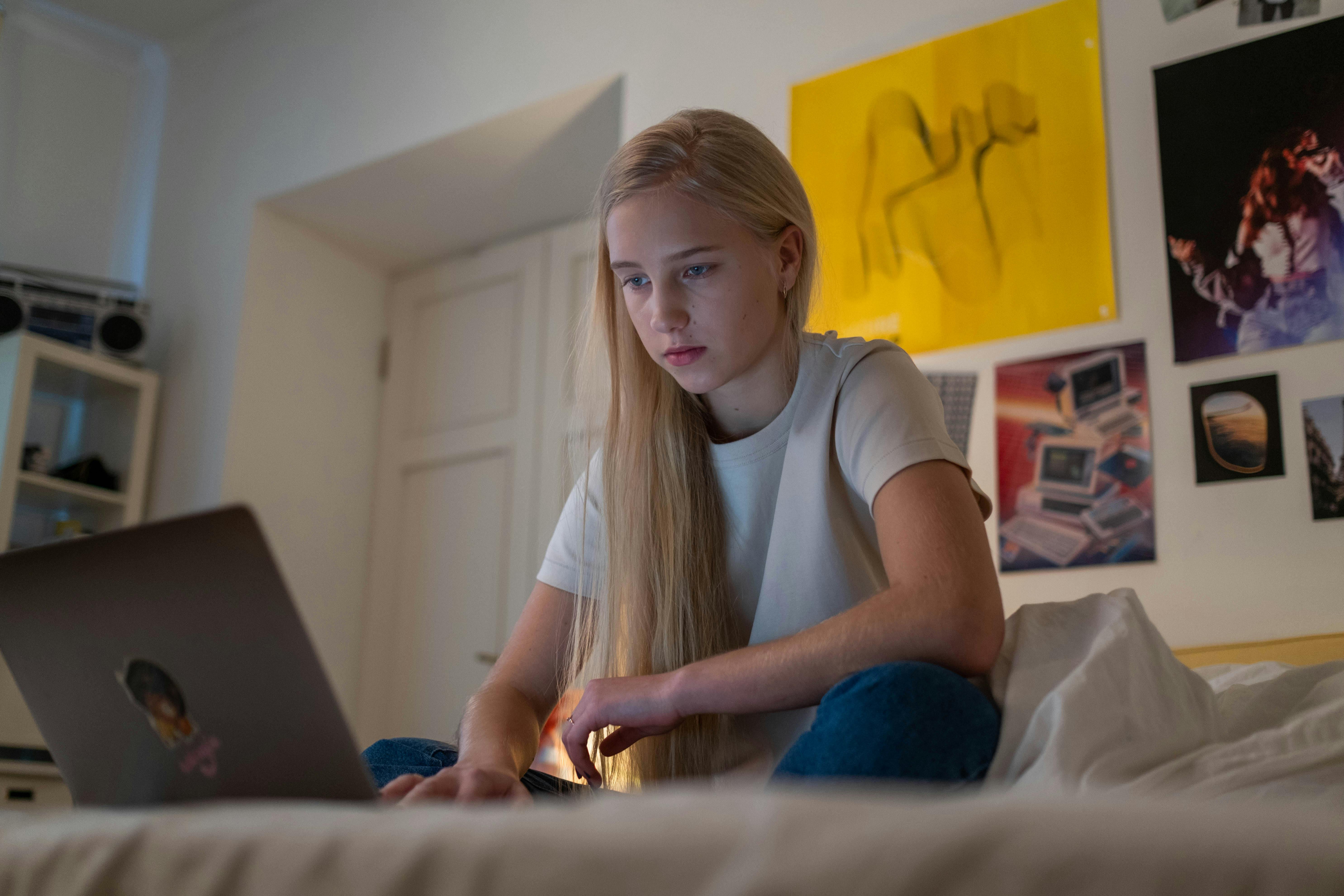 Teenager on a laptop in her bedroom