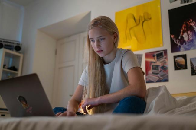 Teenager on a laptop in her bedroom