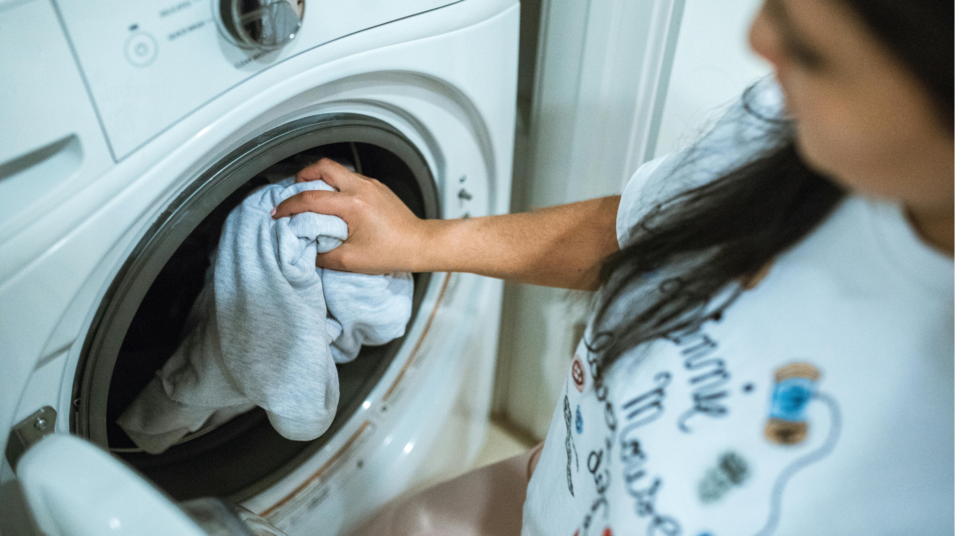someone taking washed clothes out of a washing machine