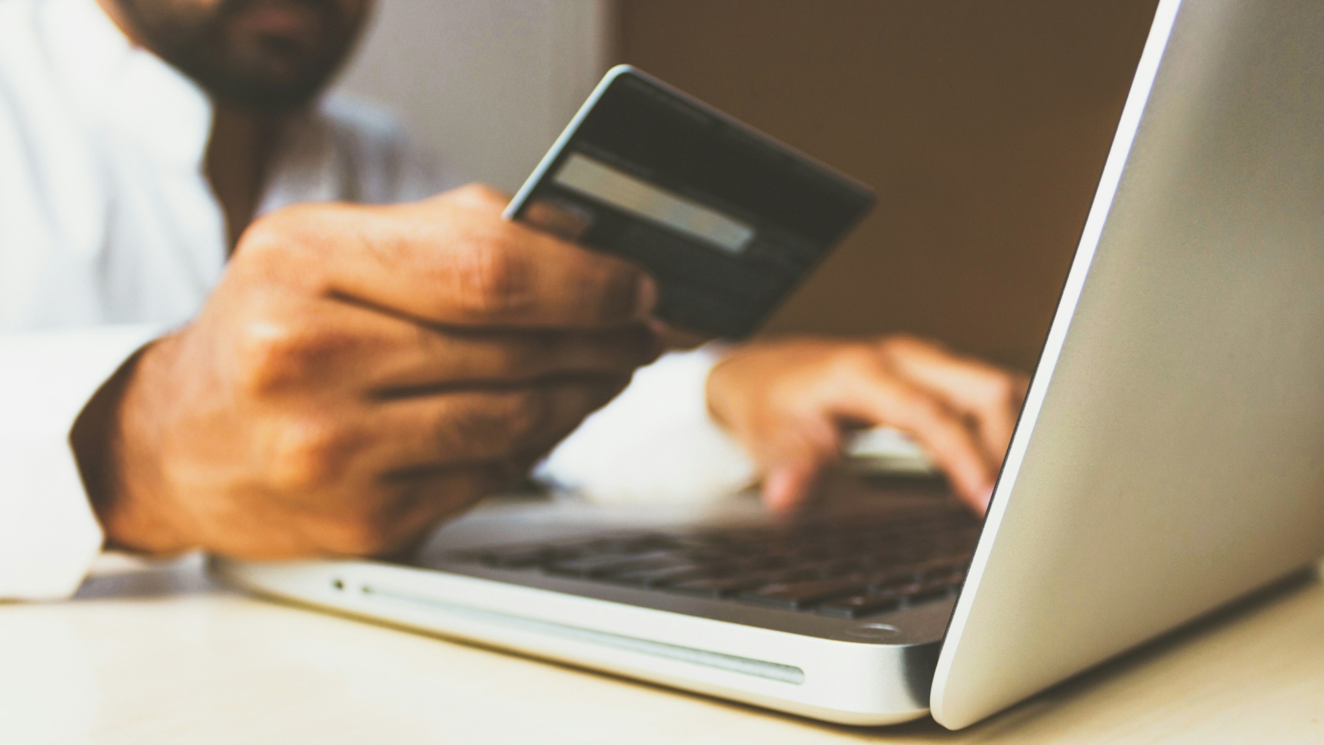 a person using a credit card at a laptop