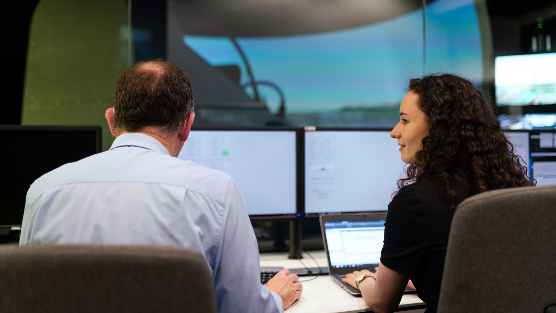 a man and a woman working at computers