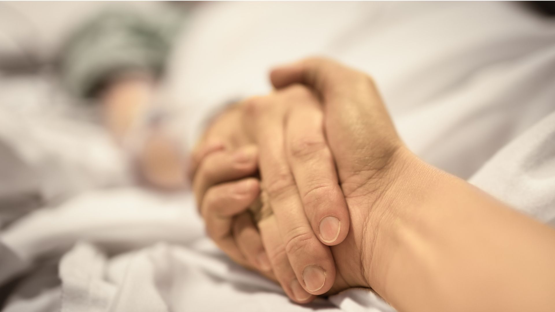 Holding hands on hospital bed