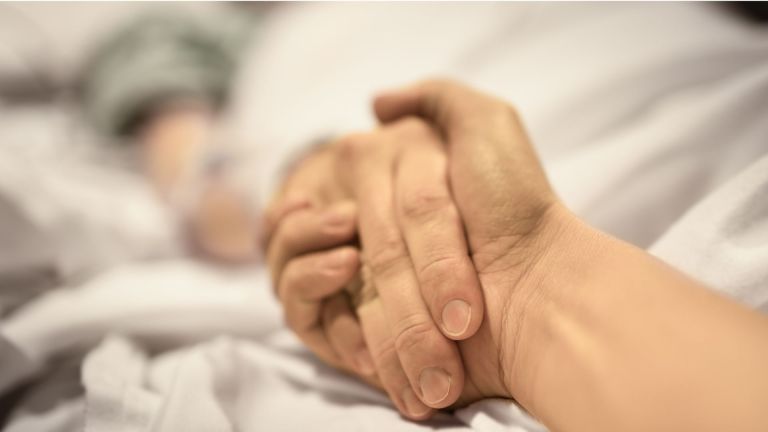 Holding hands on hospital bed