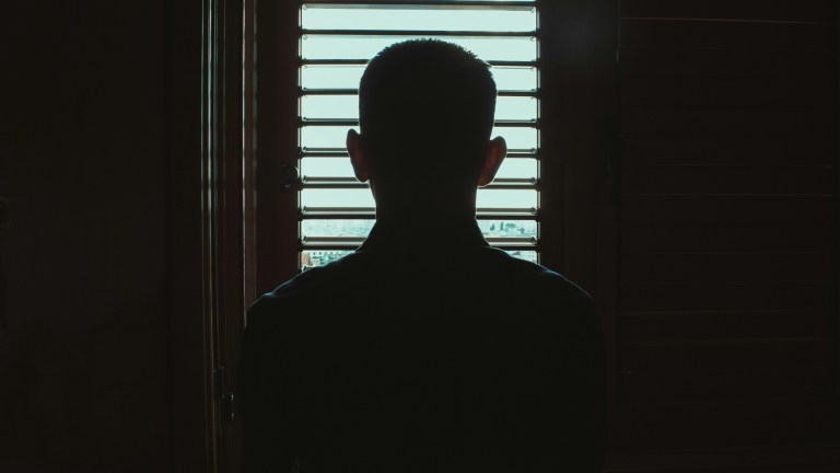 the silhouette of a young person in a home