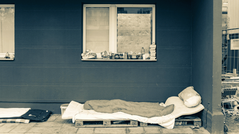 a mamkeshift bed outside a home where someone may sleep rough