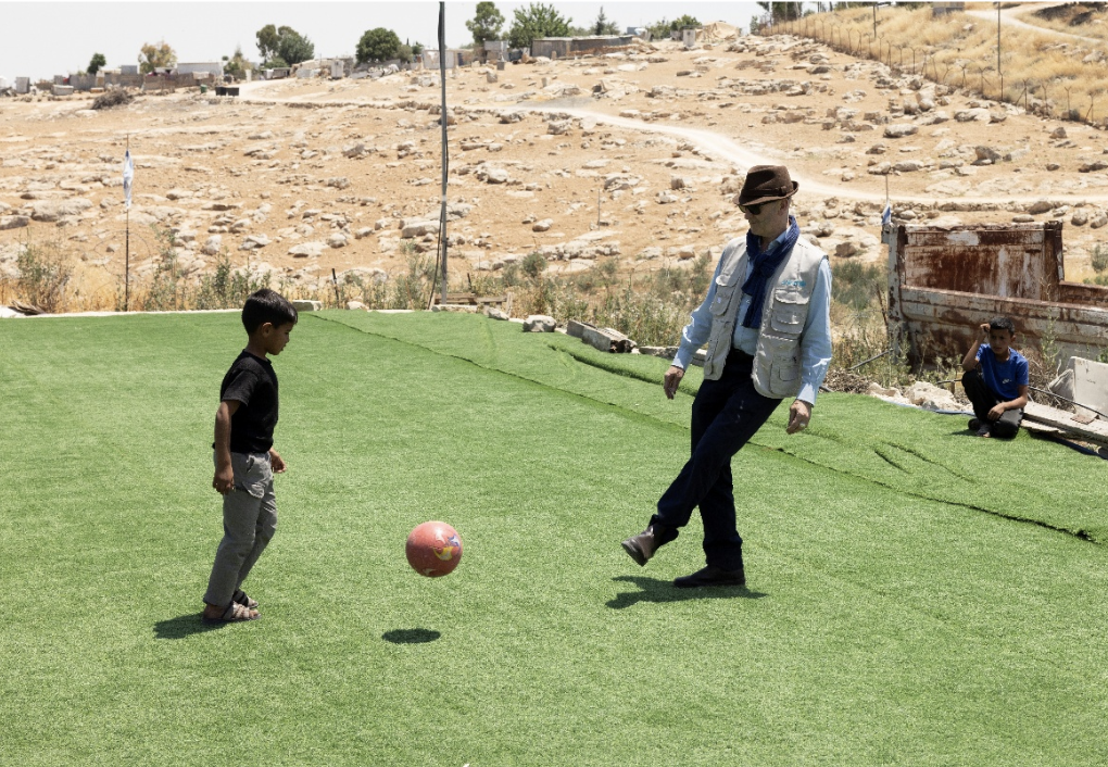 UNICEF UK CEO Dr Philip Goodwin playing football with a child in the occupied West Bank