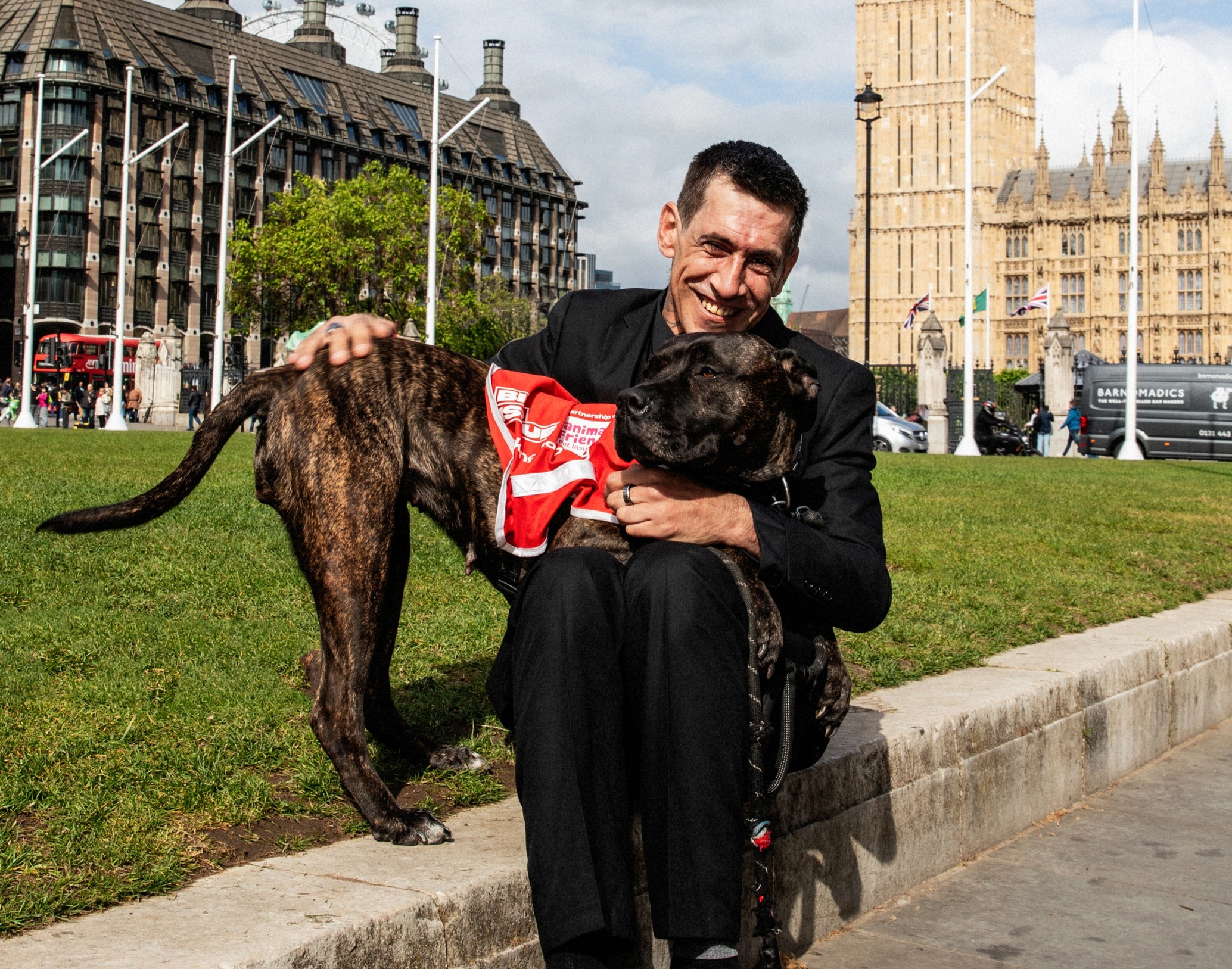 Big Issue vendor Andy sits with his dog Charm in front of Big Ben