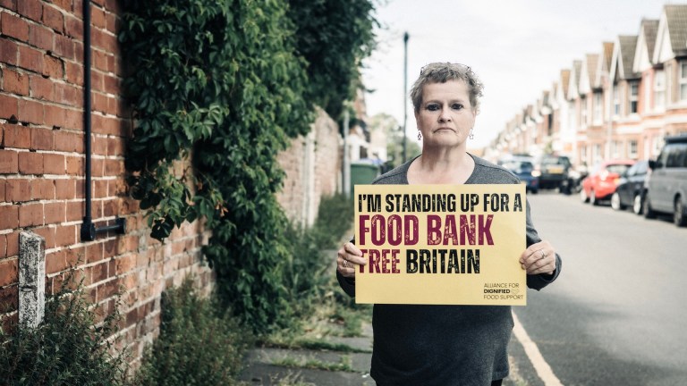 campaign imagery showing woman holding up a sign calling for a food bank free britain