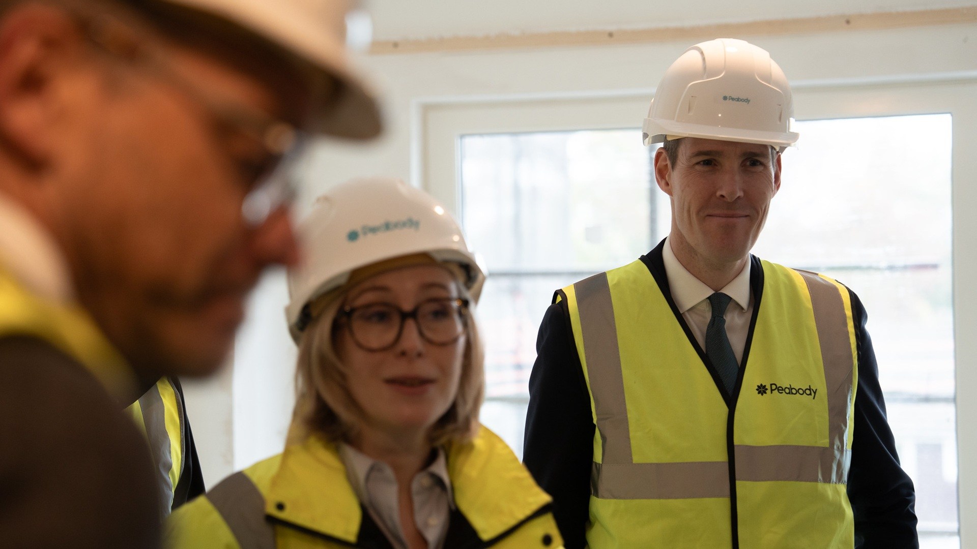 Housing minister Matthew Pennycook with two other people, all in hi-vis with hard hats