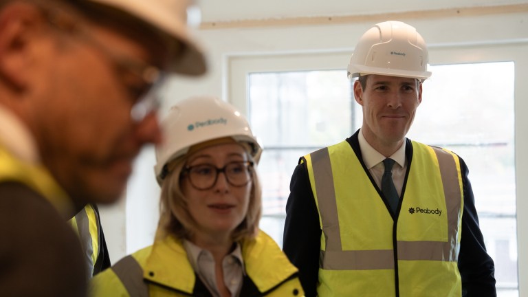 Housing minister Matthew Pennycook with two other people, all in hi-vis with hard hats