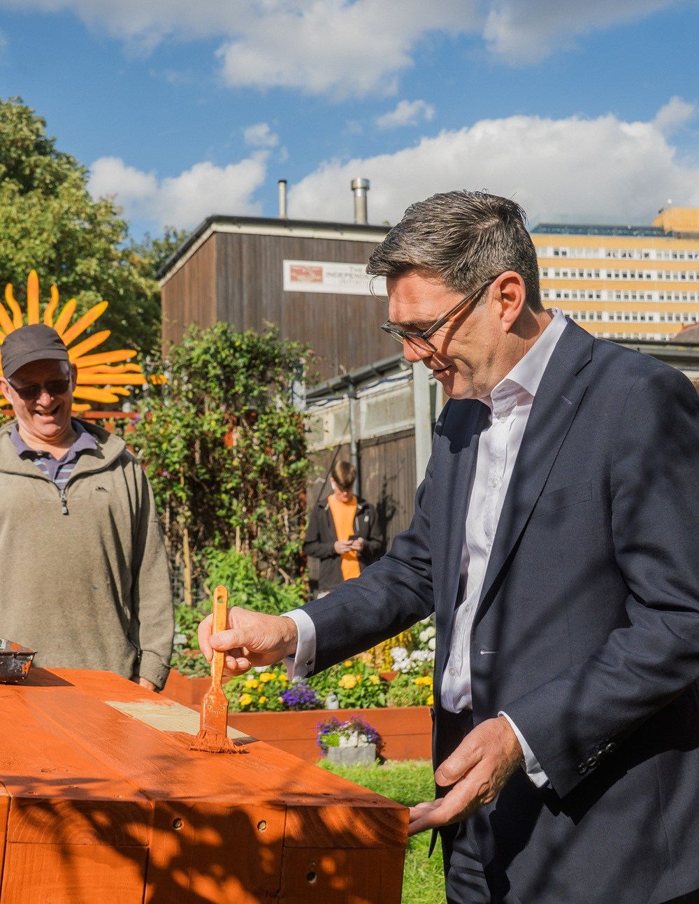 Prime minister Andy Burnham paints furniture with volunteer Dave