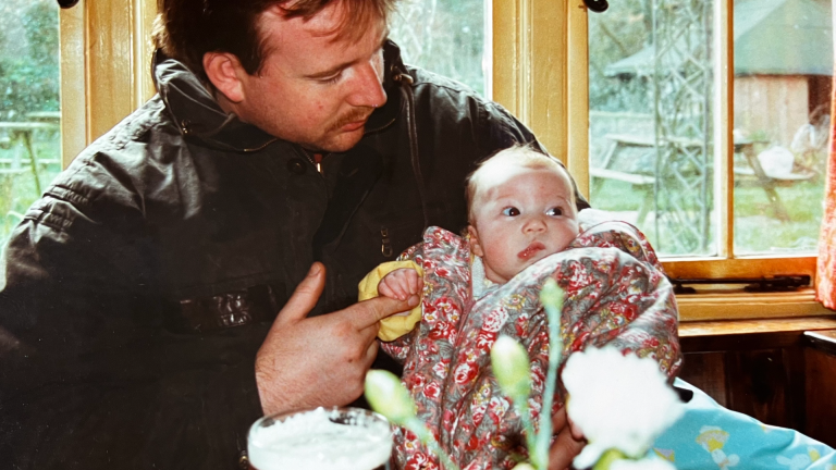 Michelle's father holding her as a baby.
