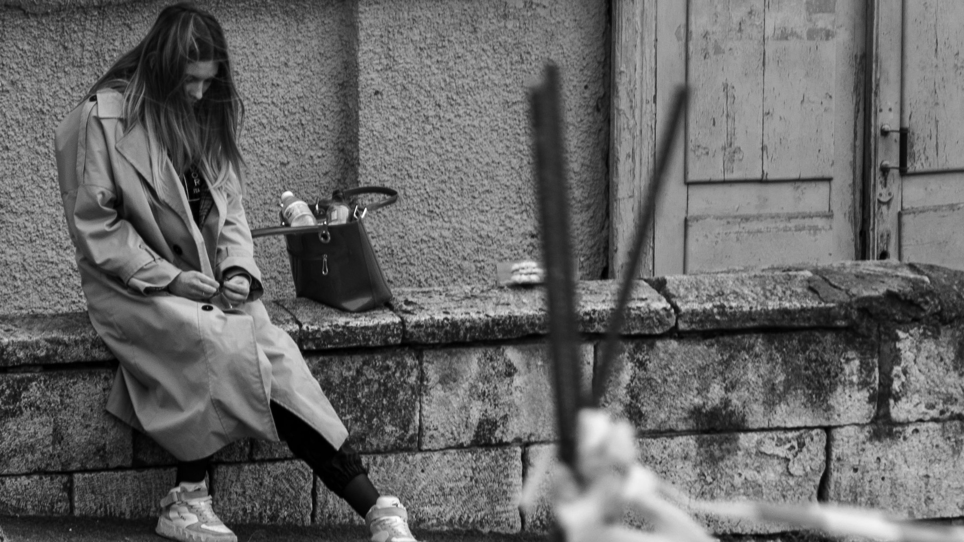 a woman sitting on the side of a road
