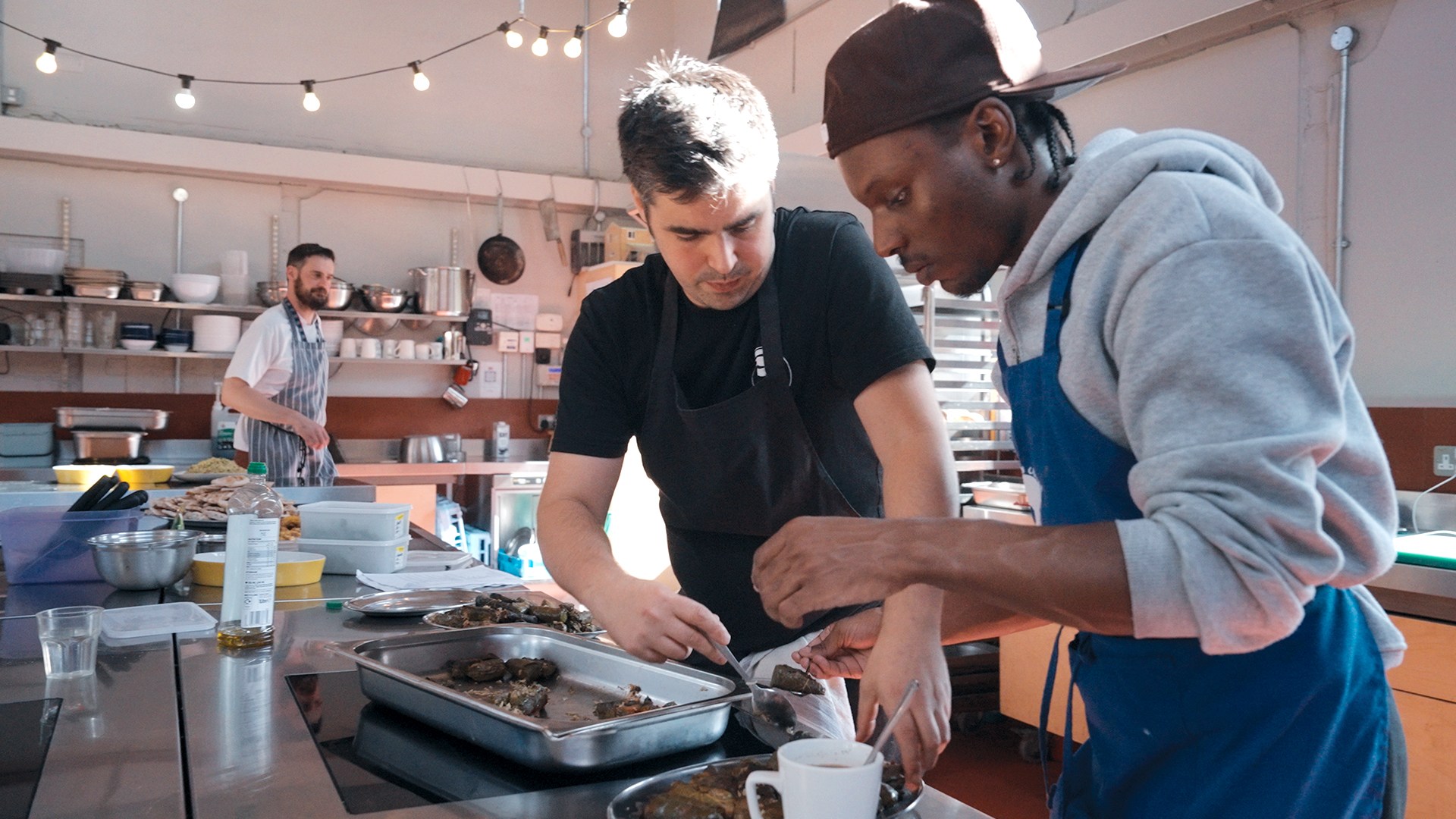 A young person being trained in the kitchen at Fat Macy's