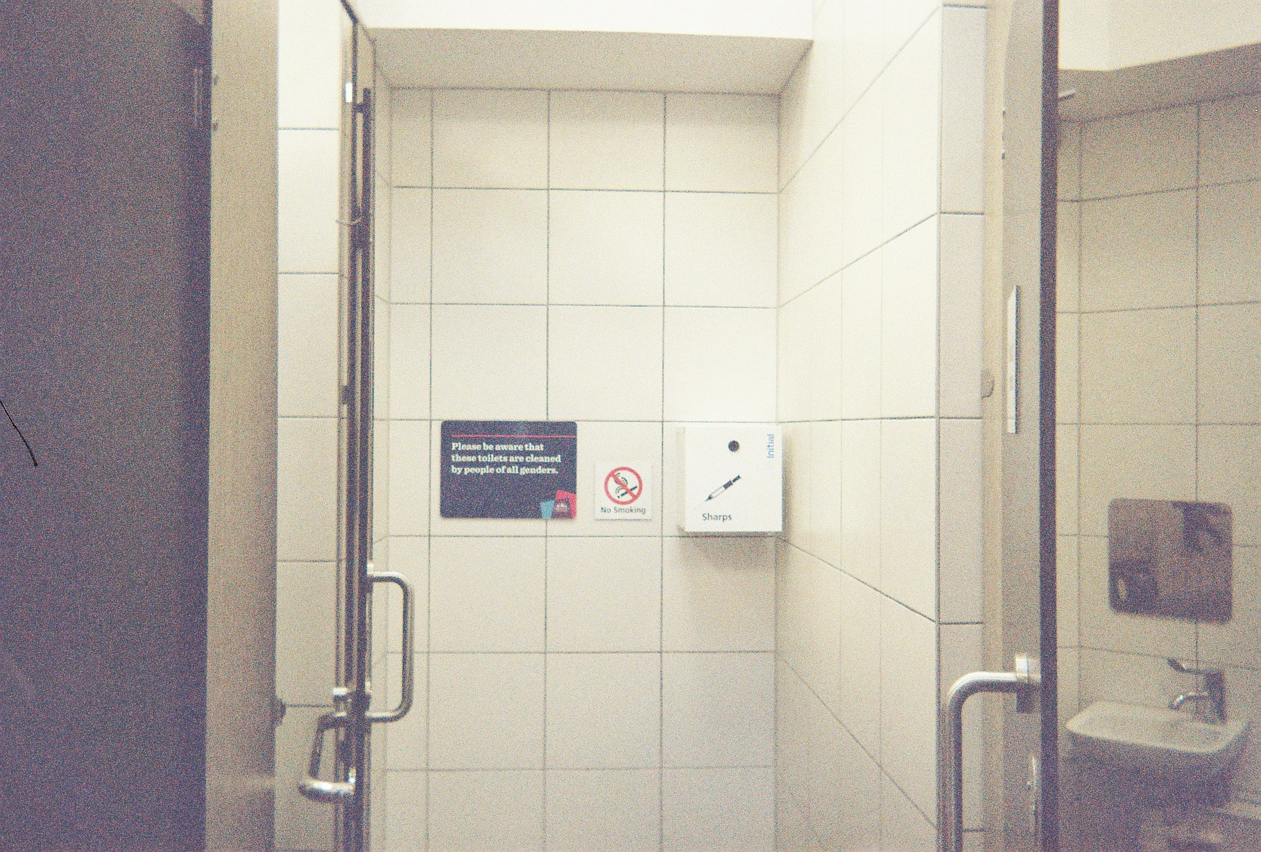 A photo of a sharps box in a public toilet