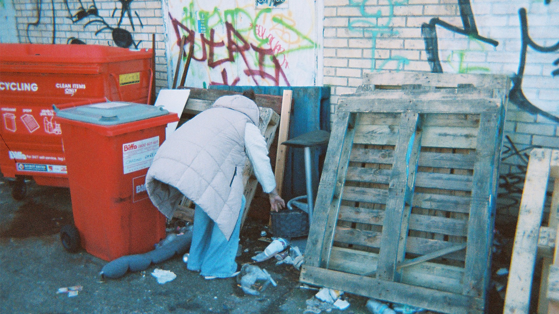 A homeless women pictured going behind the bins to get some privacy while on her period